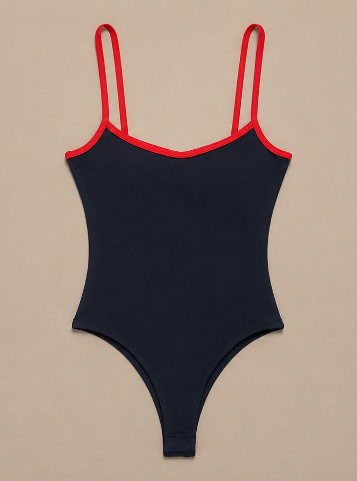 A dark navy blue one-piece bodysuit with thin red shoulder straps and red trim along the neckline, displayed flat against a solid beige background.