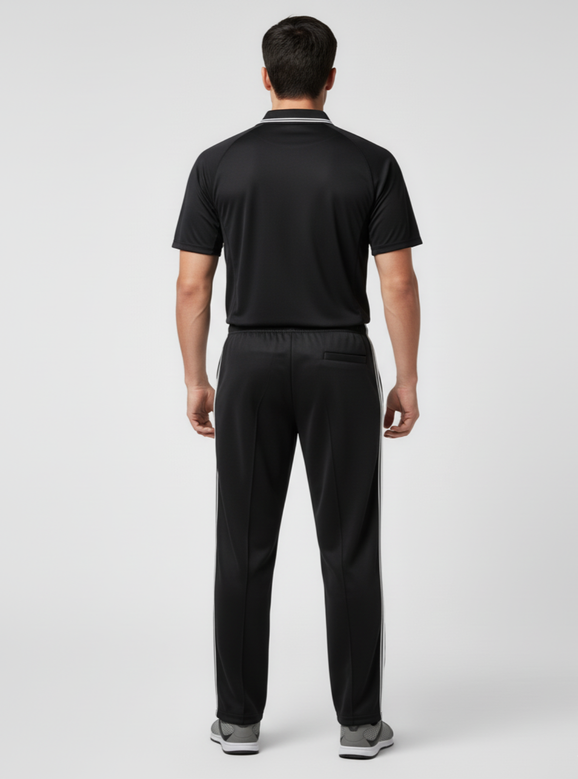 Man wearing a black polo shirt and pants on a white background