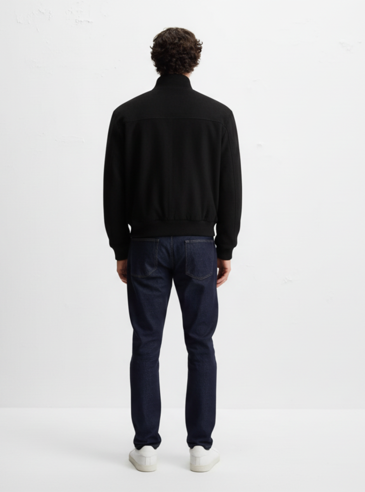 Person wearing a black turtleneck and dark pants on a white background