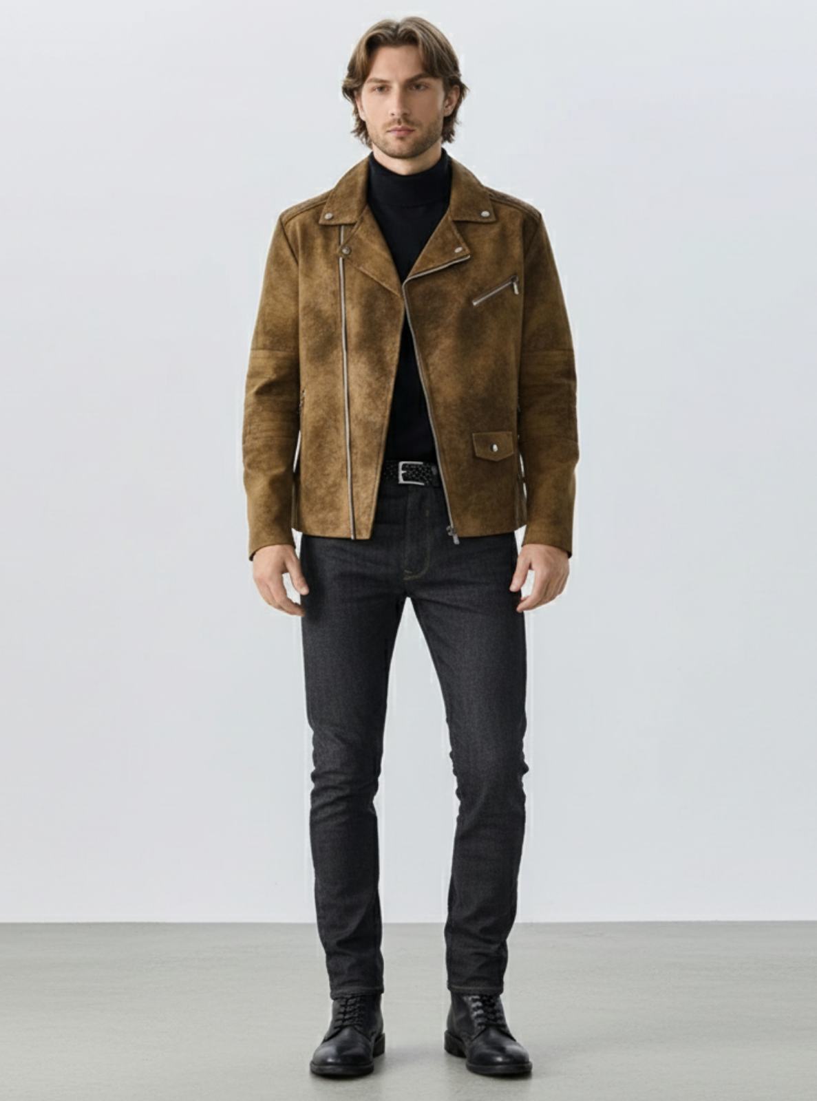 Man wearing a brown suede jacket and black jeans against a white background