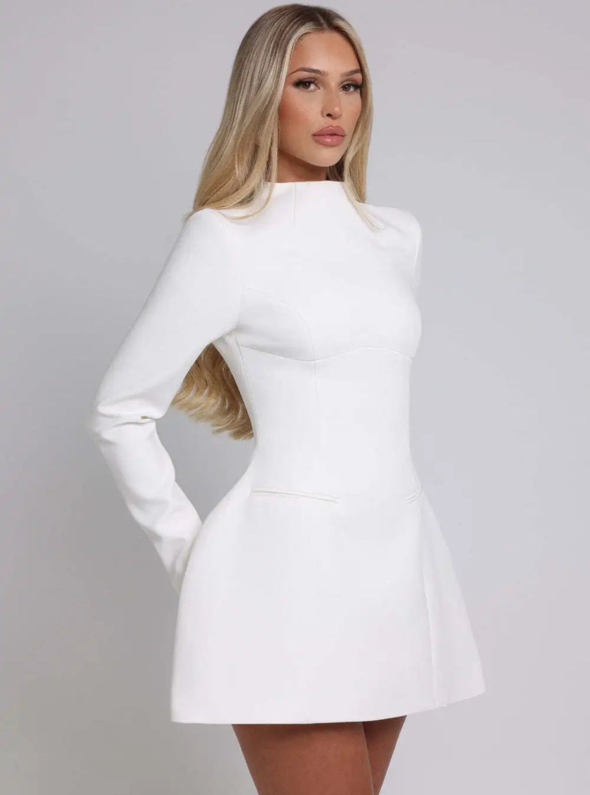 Woman wearing a white dress against a gray background