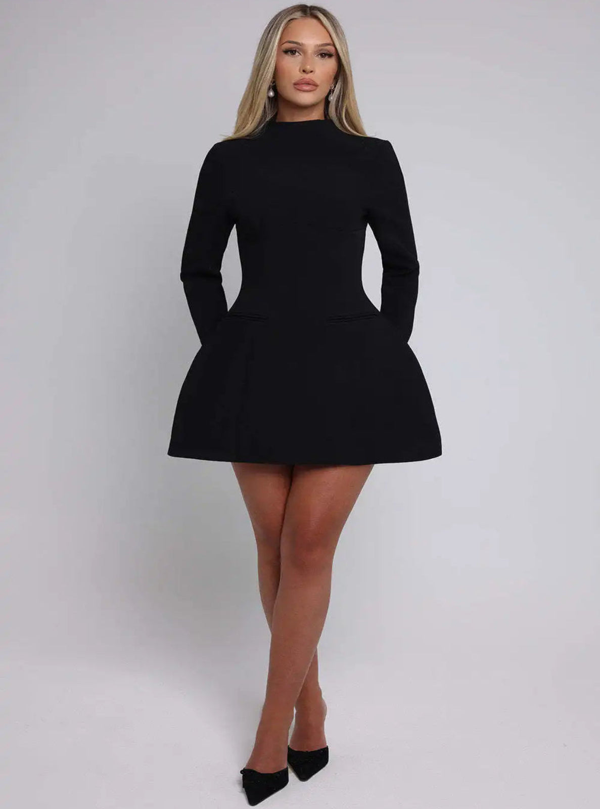 Woman wearing a black dress against a plain background
