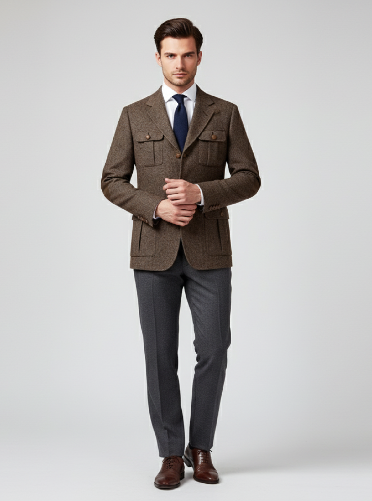 Man wearing a brown blazer and gray pants on a white background