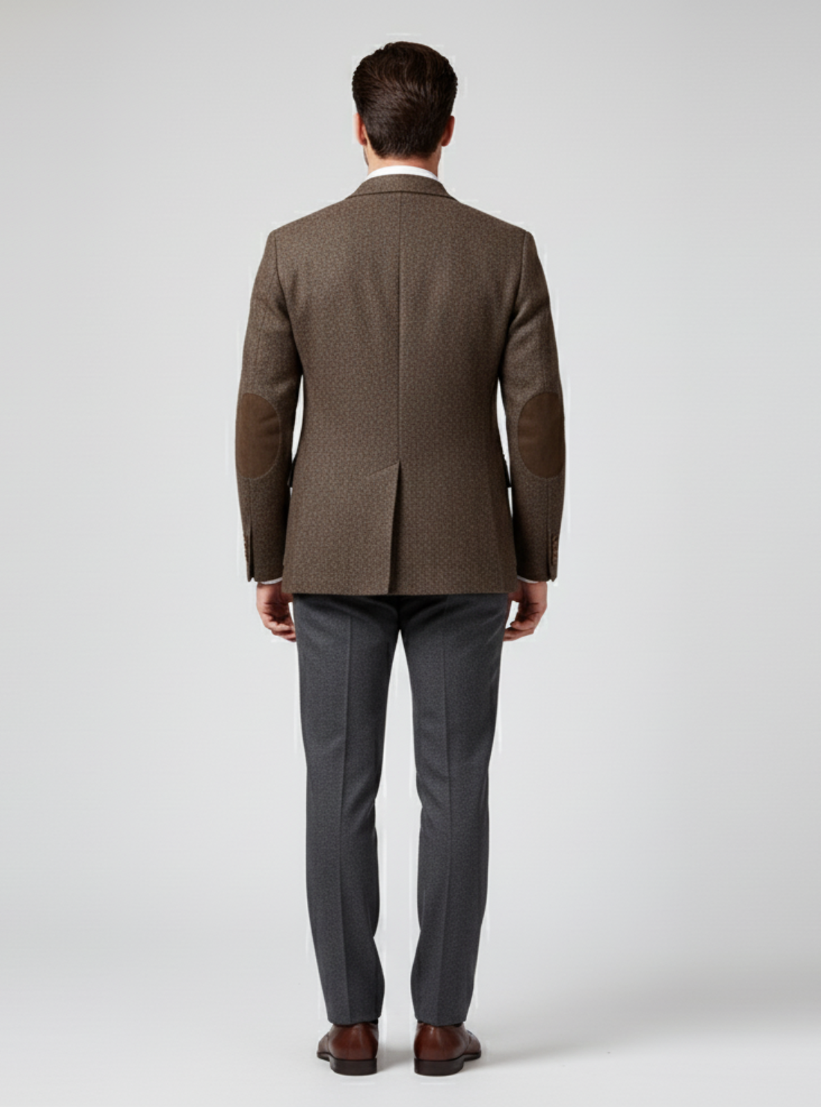 Man wearing a brown blazer and gray pants on a white background