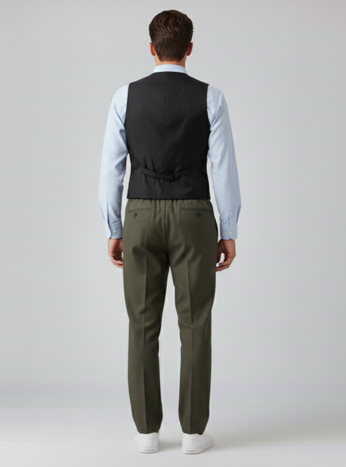 Man wearing a black vest and green pants on a white background