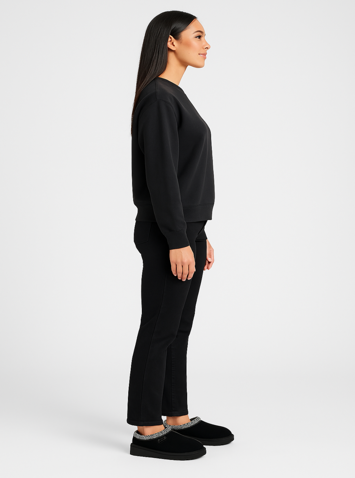 Woman wearing a black outfit with black shoes on a white background
