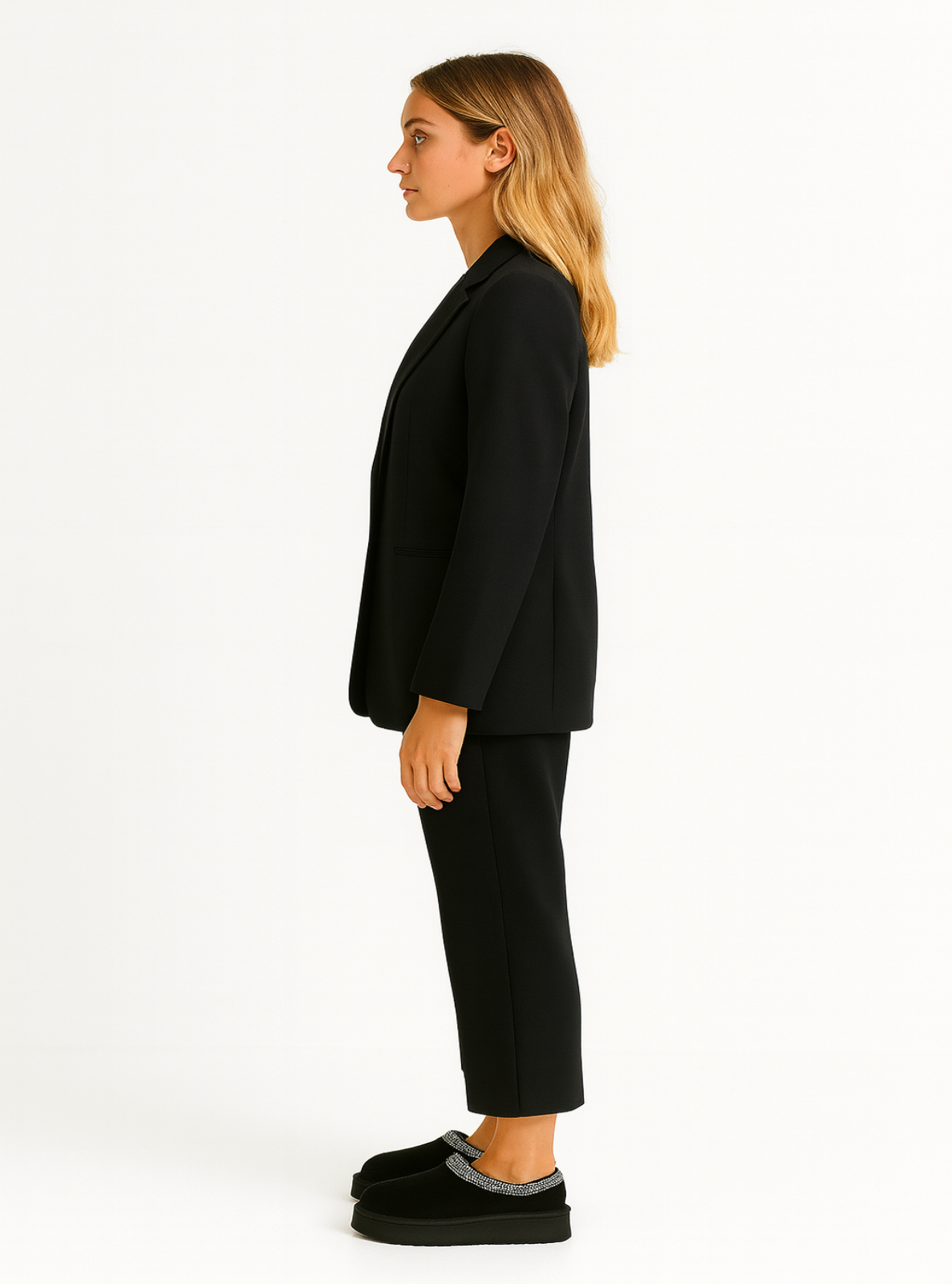 Woman wearing a black suit with black slippers on a white background