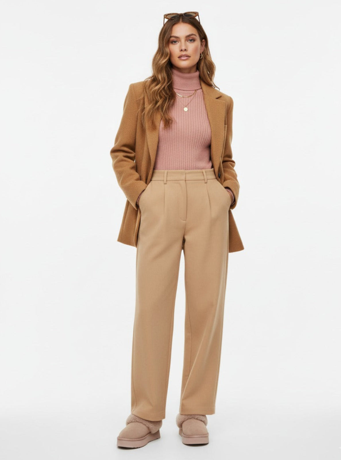 Woman wearing a beige suit with a pink top on a white background