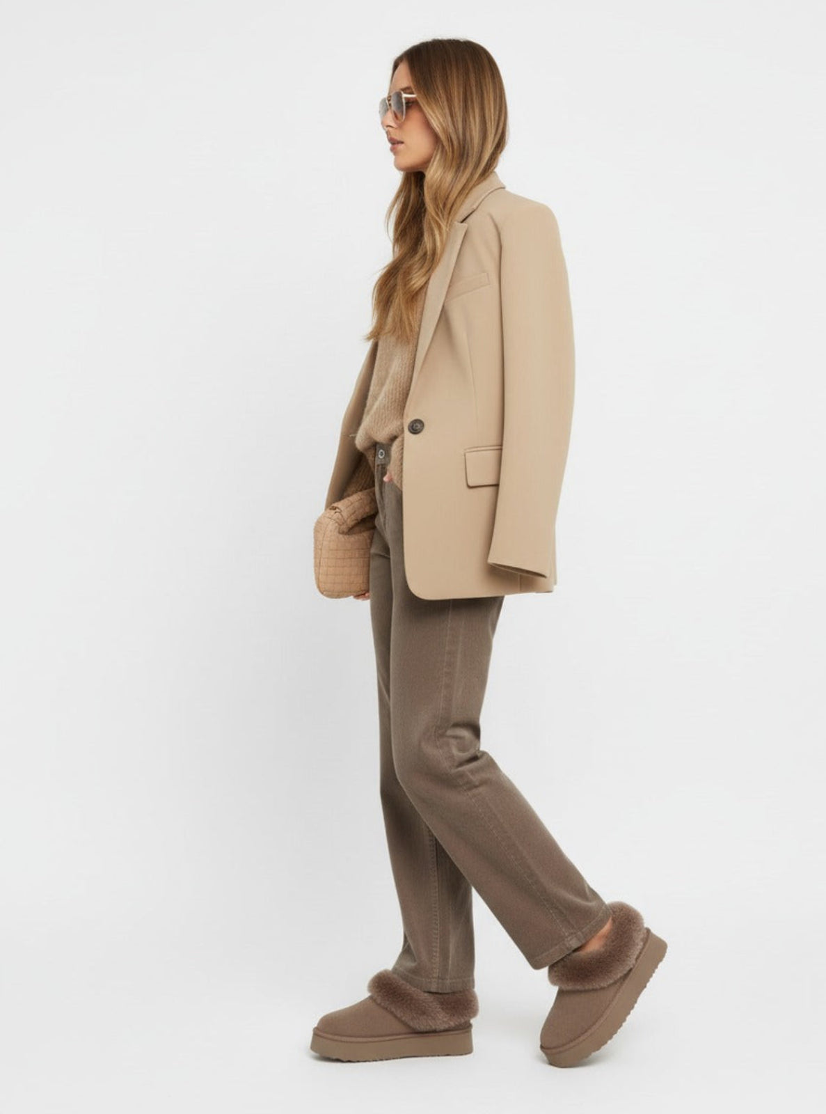 Woman wearing a beige suit with brown shoes on a white background