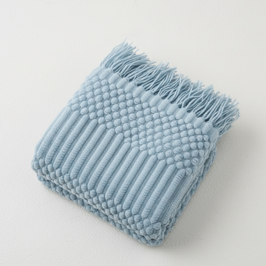 Light blue textured blanket on a light gray background