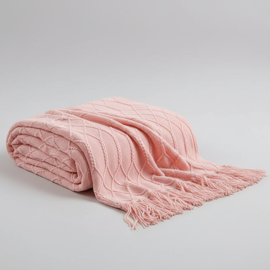 Pink textured blanket with fringes on a light gray background