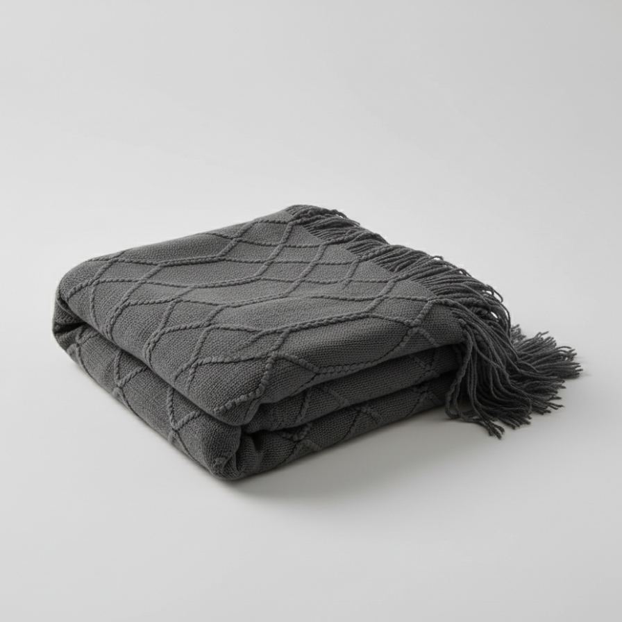 Folded gray blanket with fringes on a light gray background