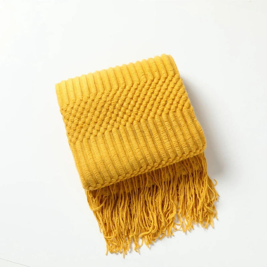 Yellow knitted scarf with fringes on a white background