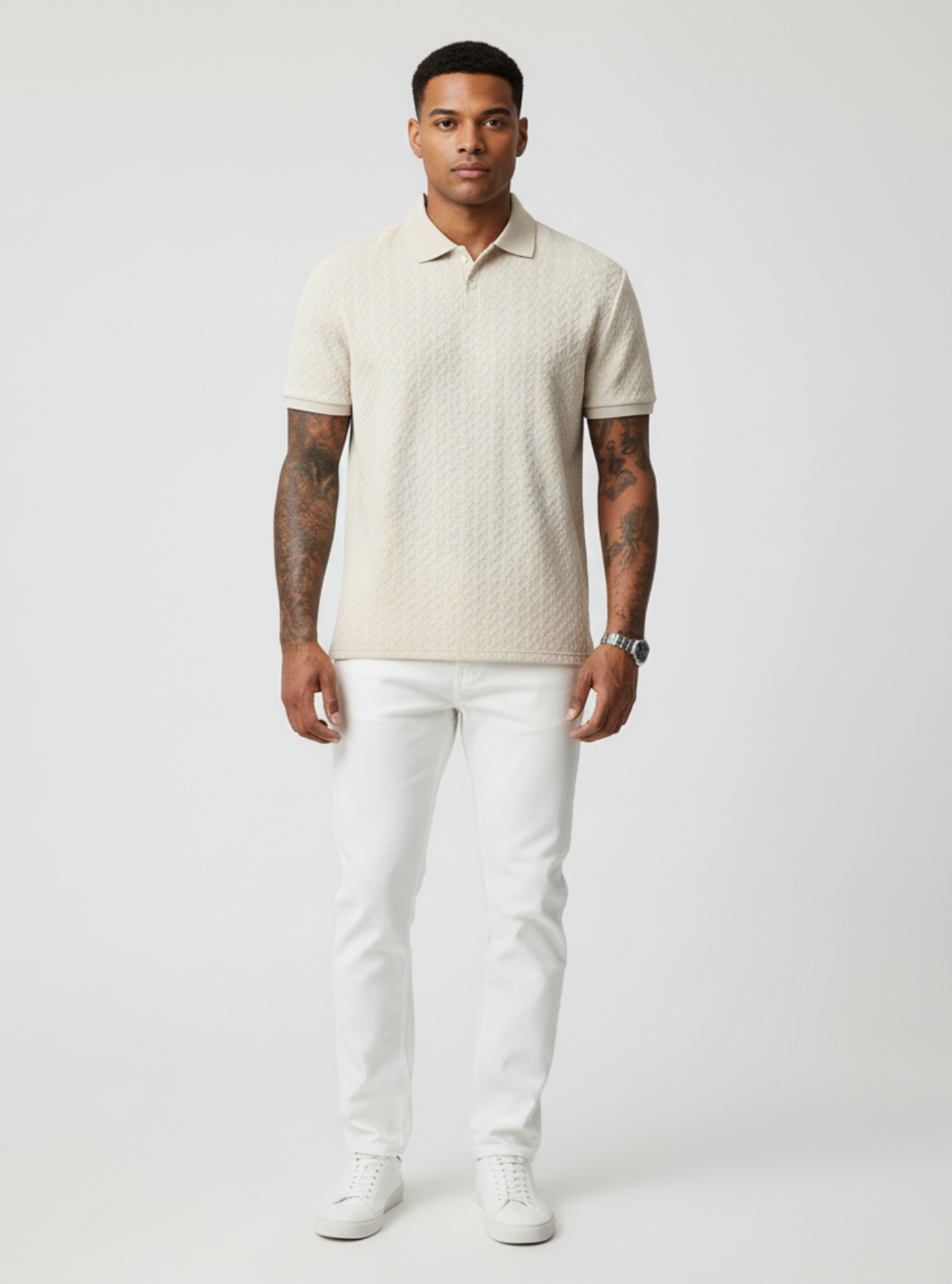 Man wearing a beige textured polo shirt and white pants on a light gray background