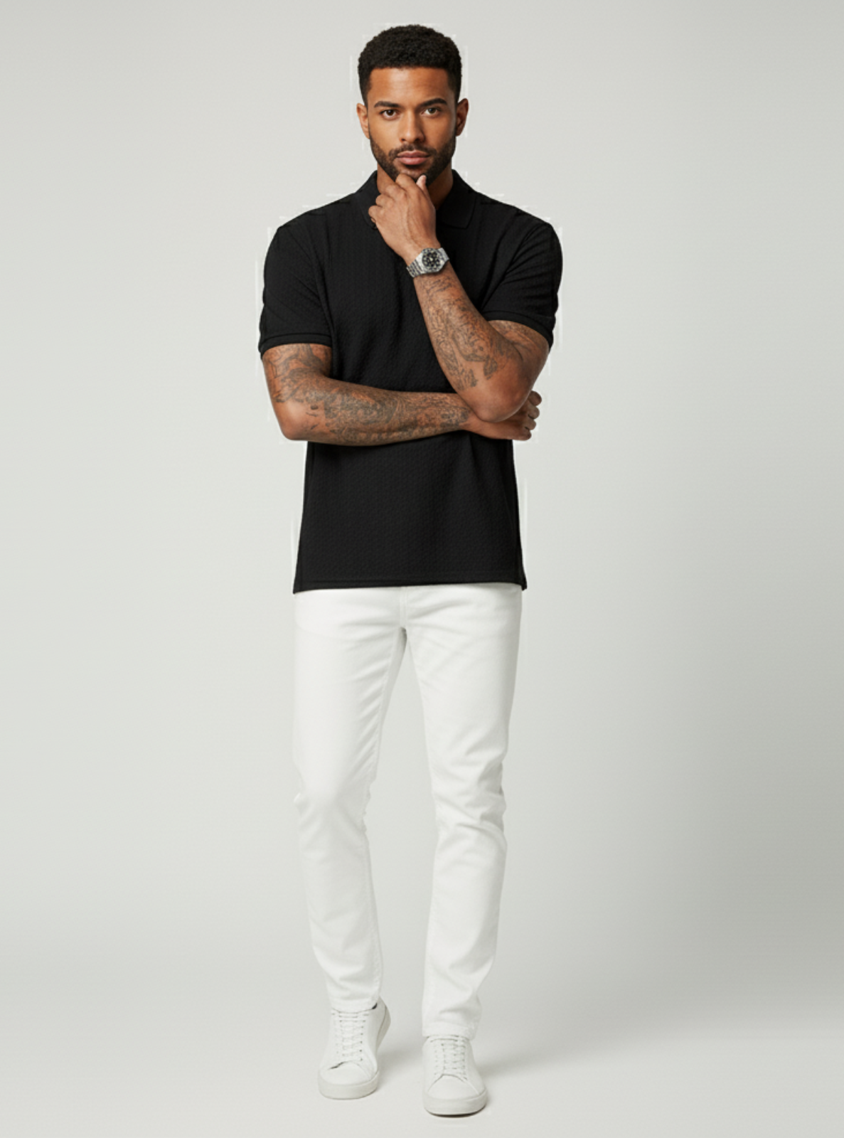 Man wearing a black shirt and white pants on a gray background