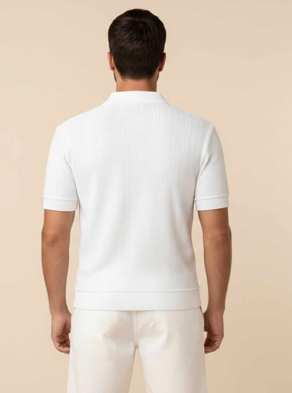 Man wearing a white polo shirt and pants on a beige background