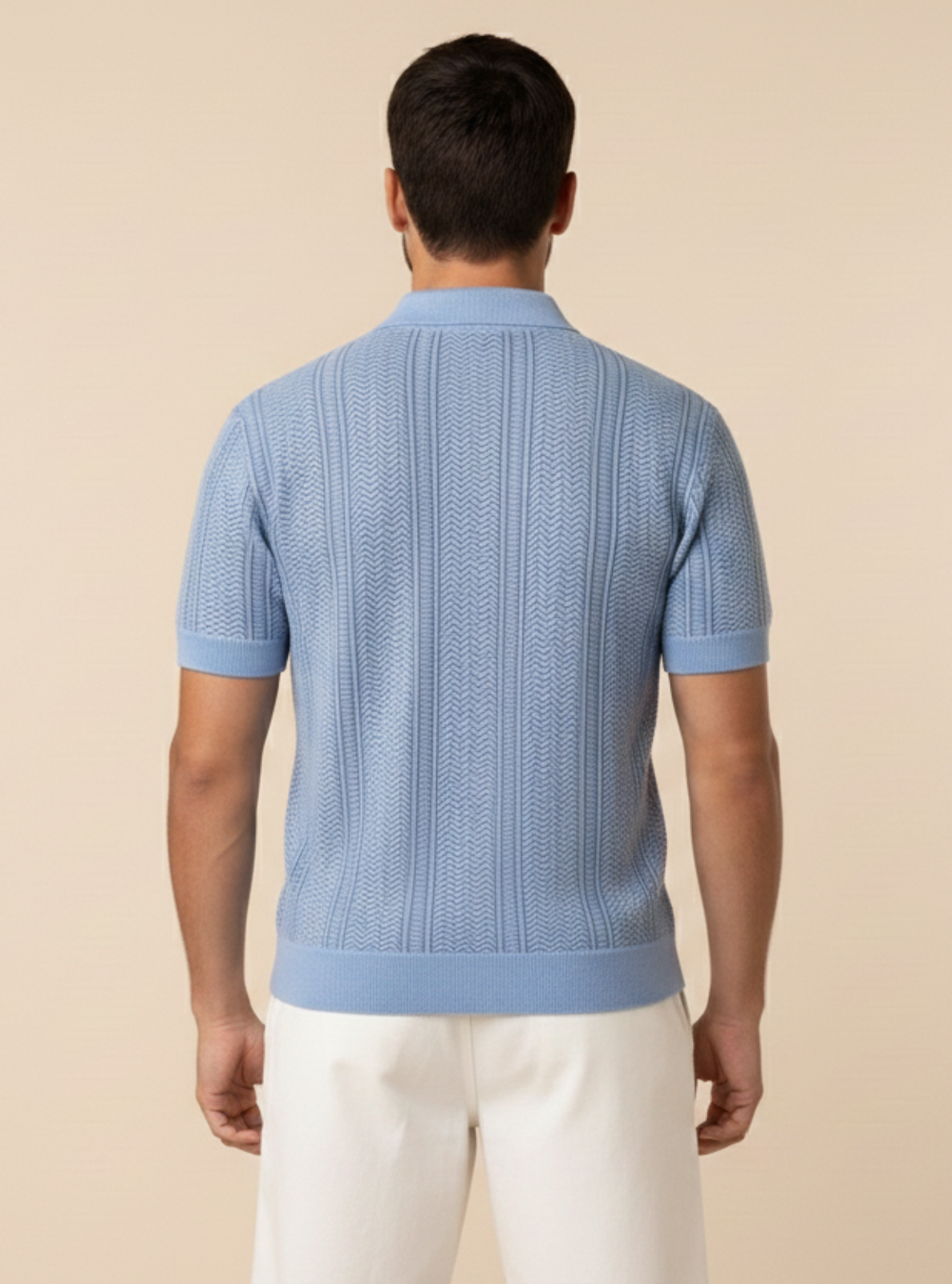 Man wearing a light blue textured short-sleeve shirt and white pants on a beige background