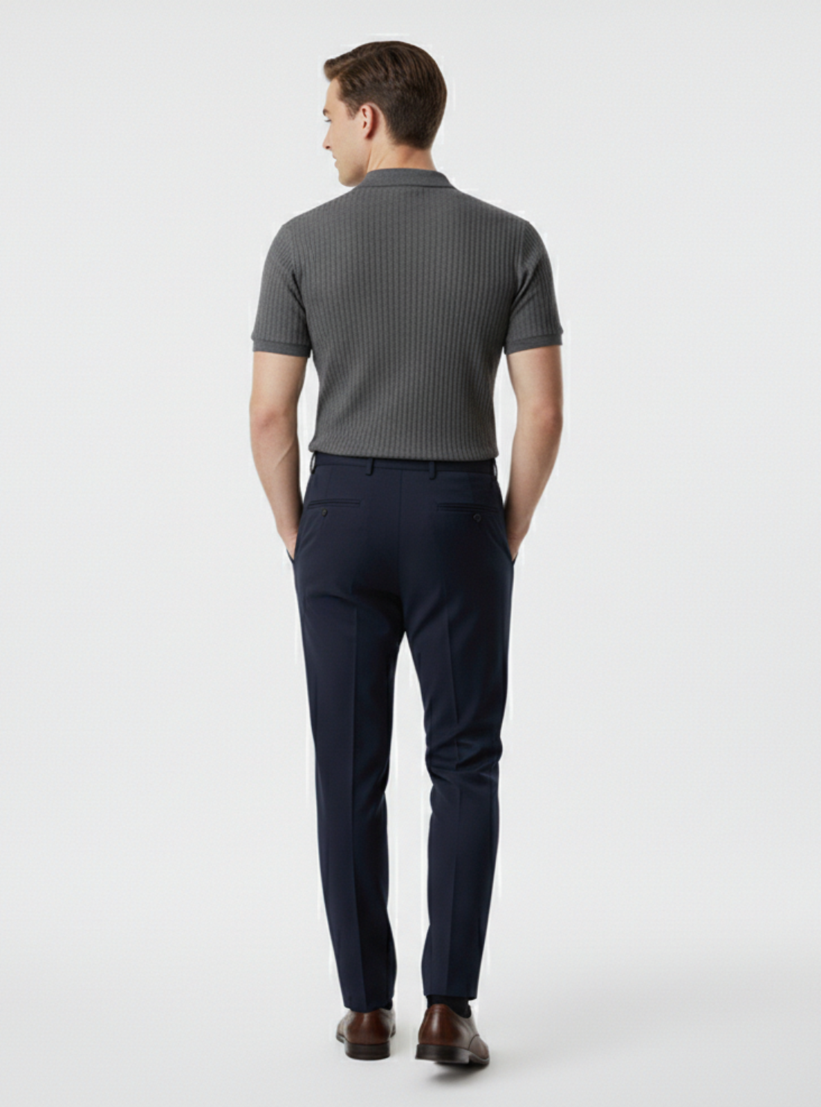 Man wearing a gray ribbed sweater and navy pants on a light gray background