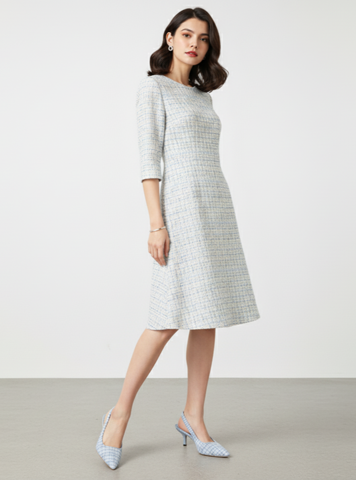 Woman wearing a checkered dress with a plain background