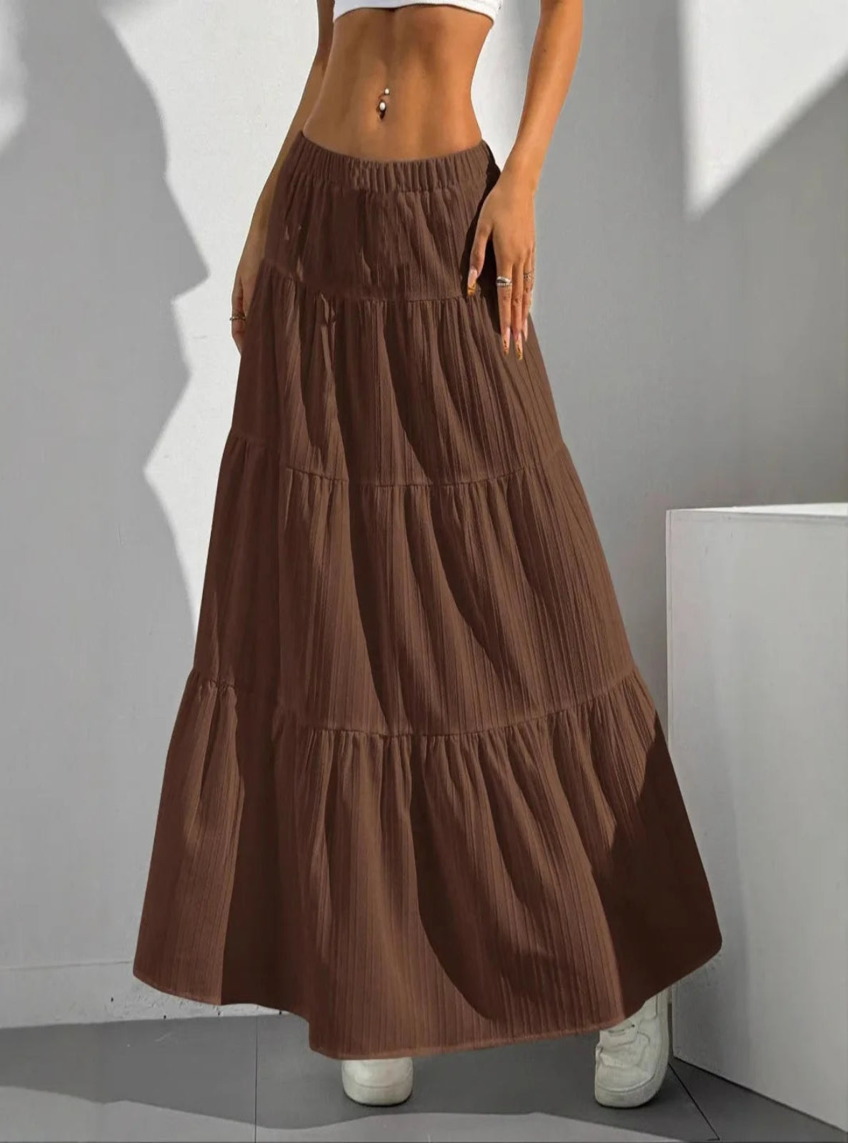 Brown tiered skirt worn by a person against a neutral background