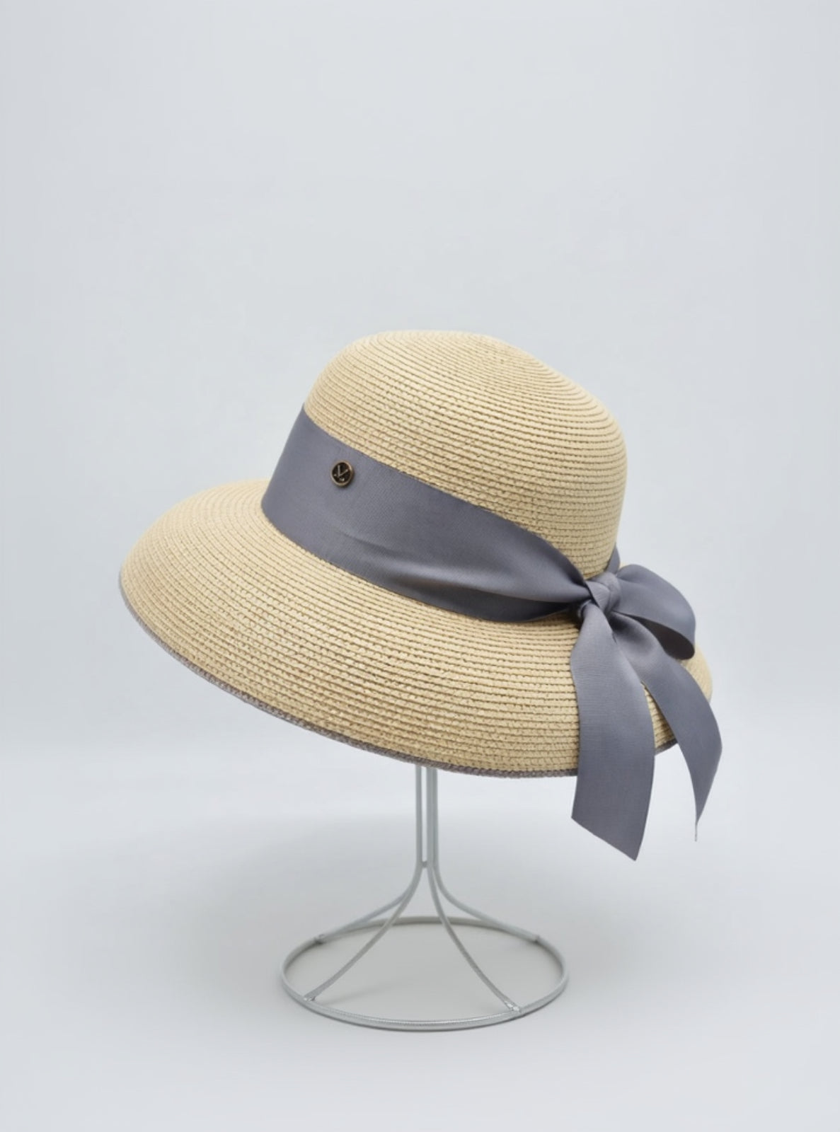 Beige straw hat with a gray ribbon on a light gray background