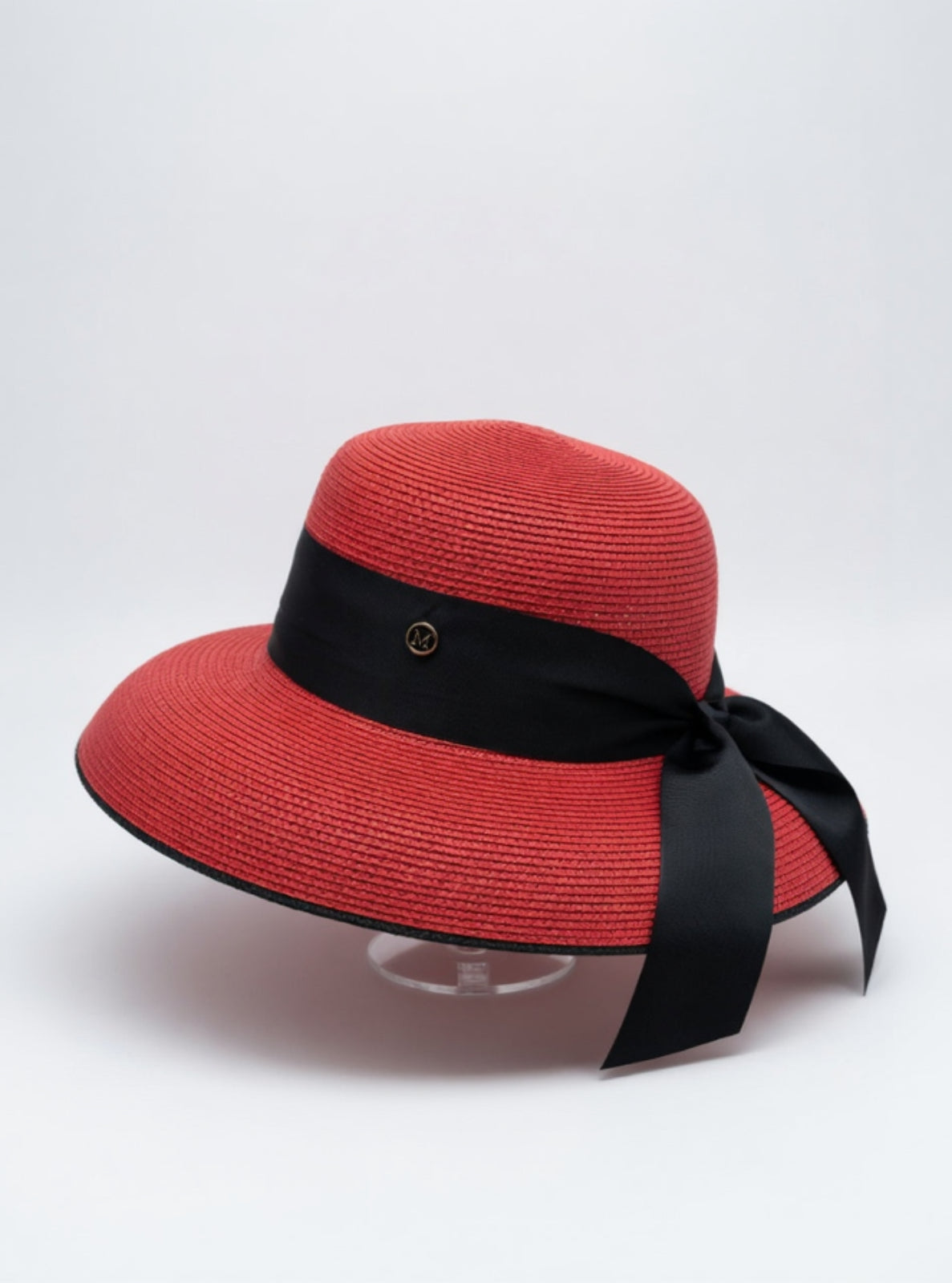 Red straw hat with a black ribbon on a white background