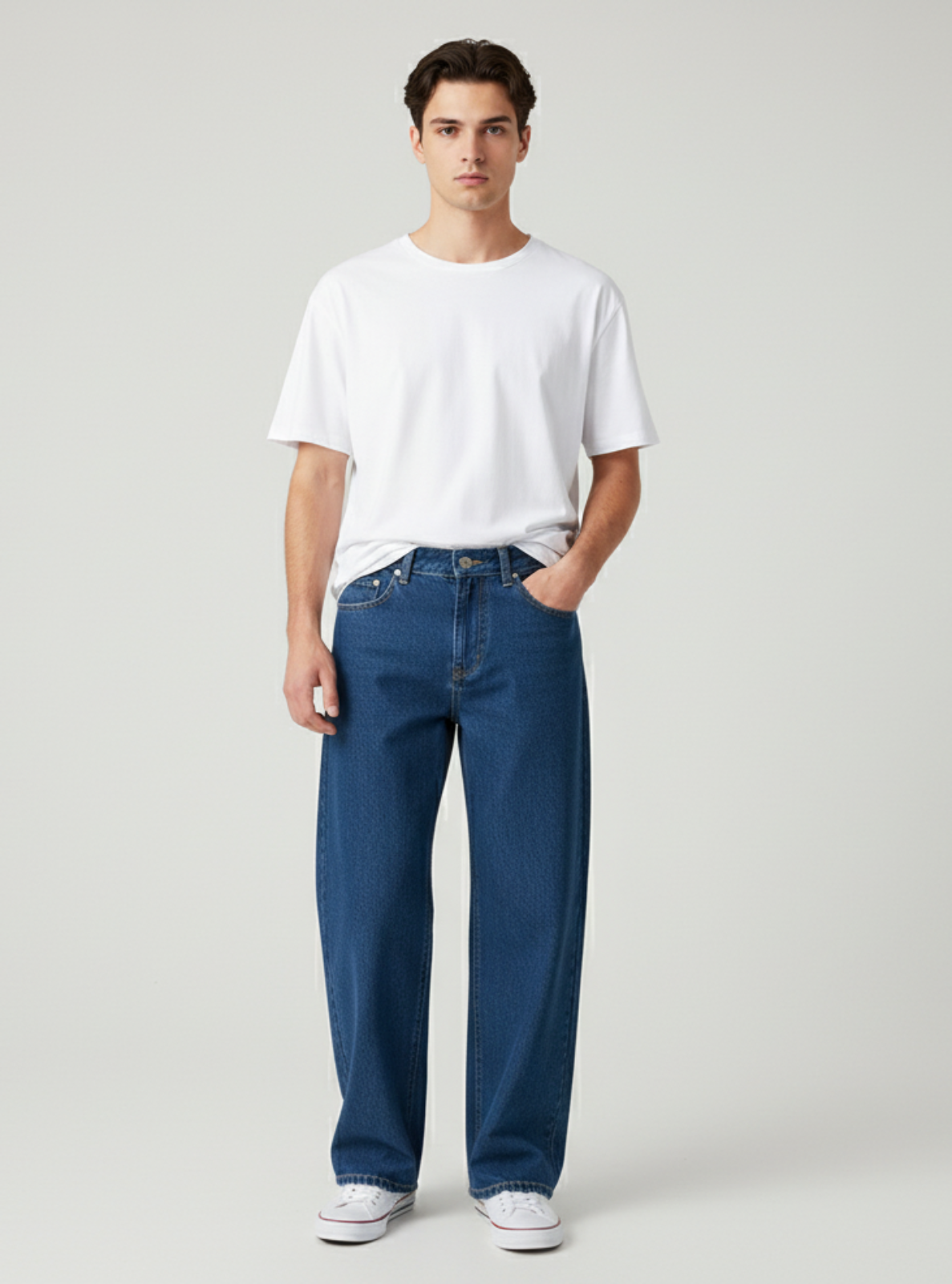 Man wearing a white t-shirt and blue jeans on a light gray background