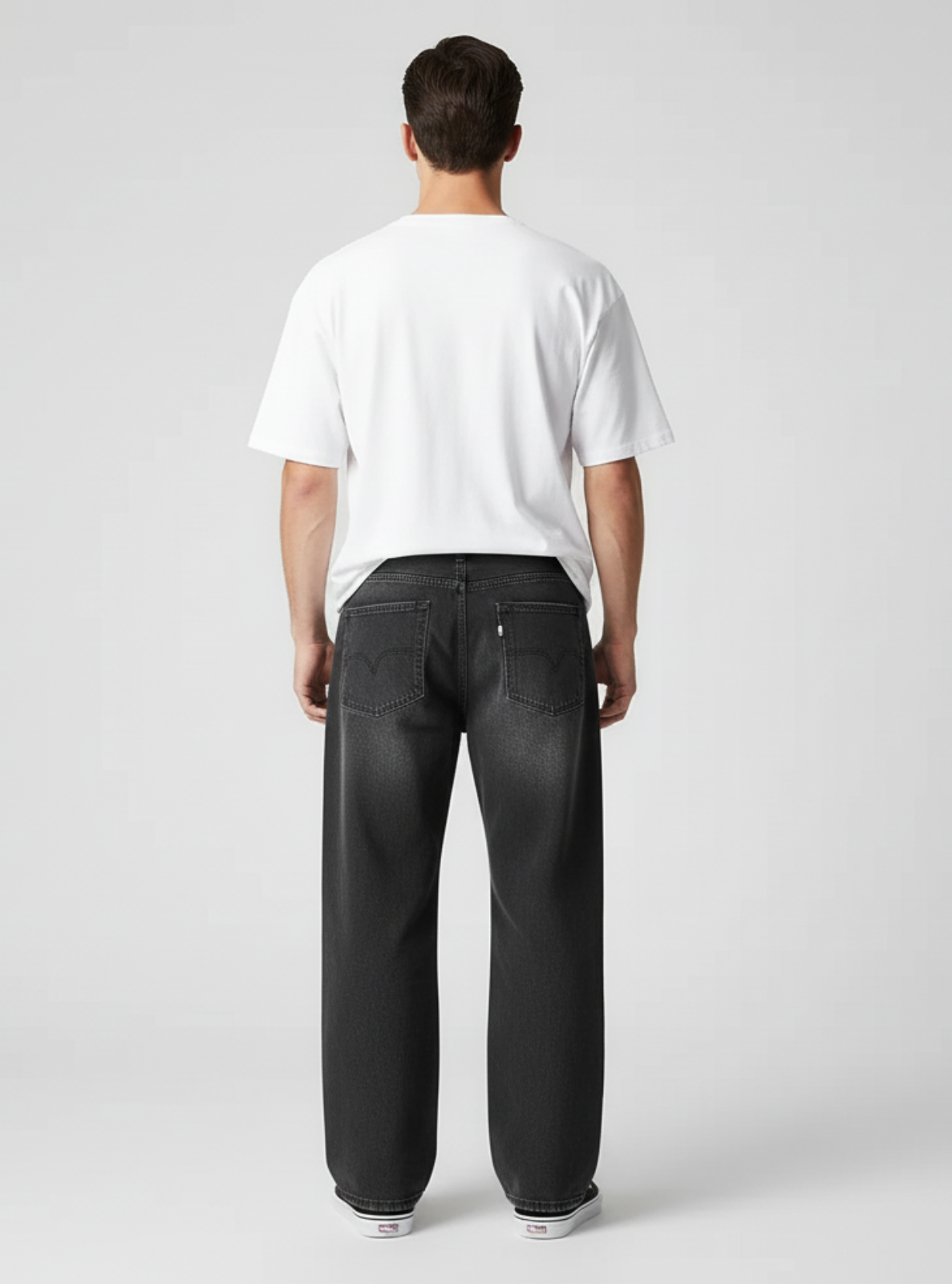 Person wearing black pants and a white shirt on a plain background