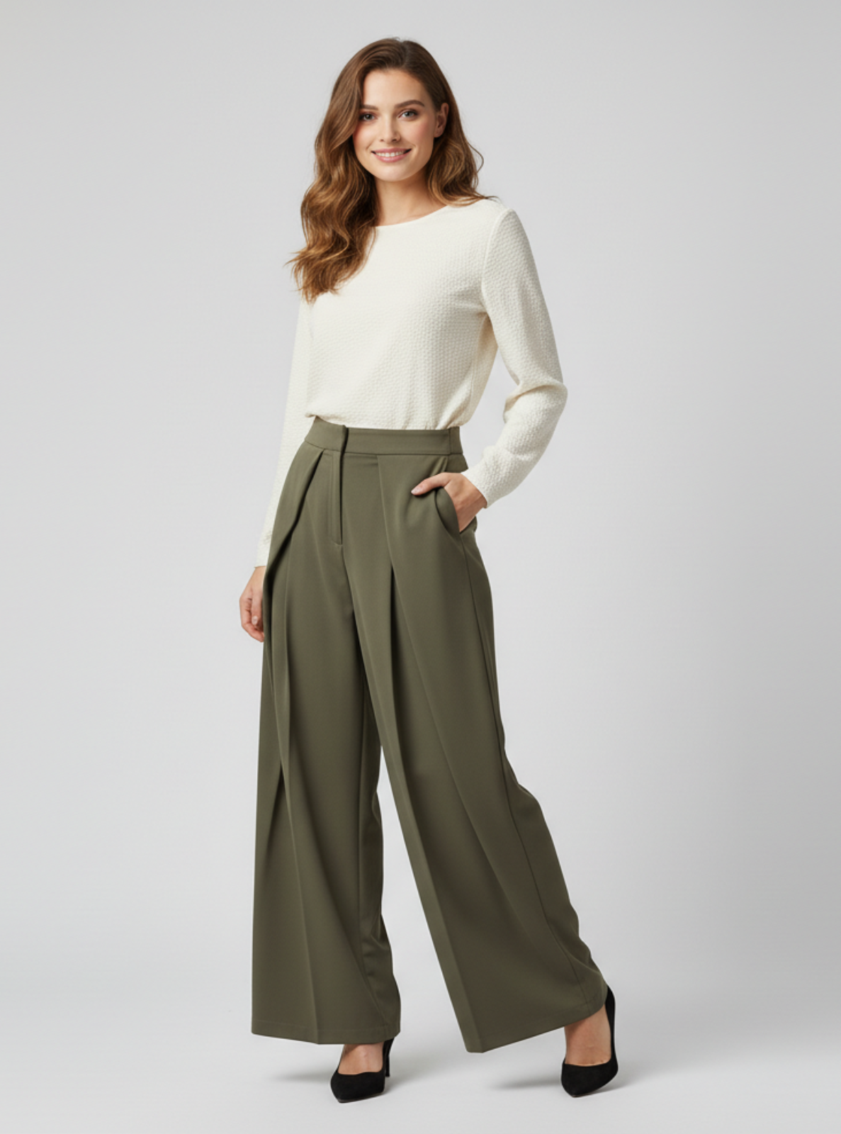 Woman wearing a white top and olive green wide-leg pants on a light gray background