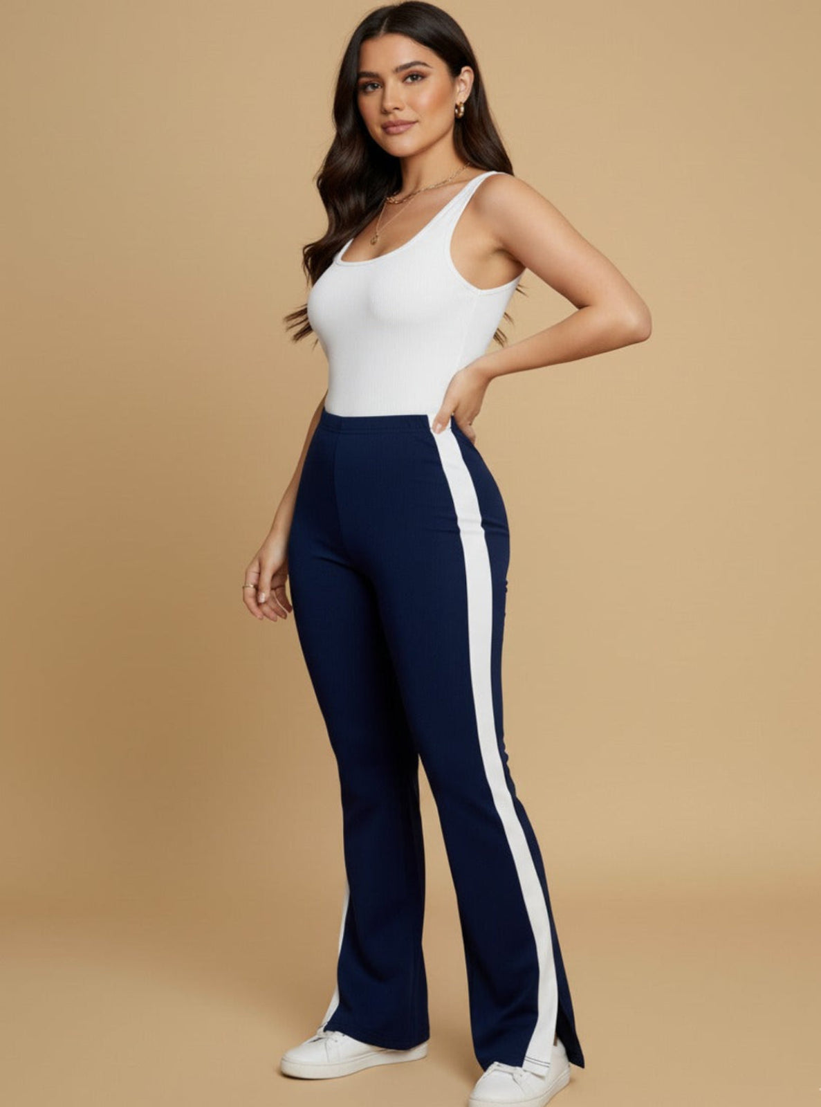 Woman wearing a white top and navy pants with a white stripe on a beige background