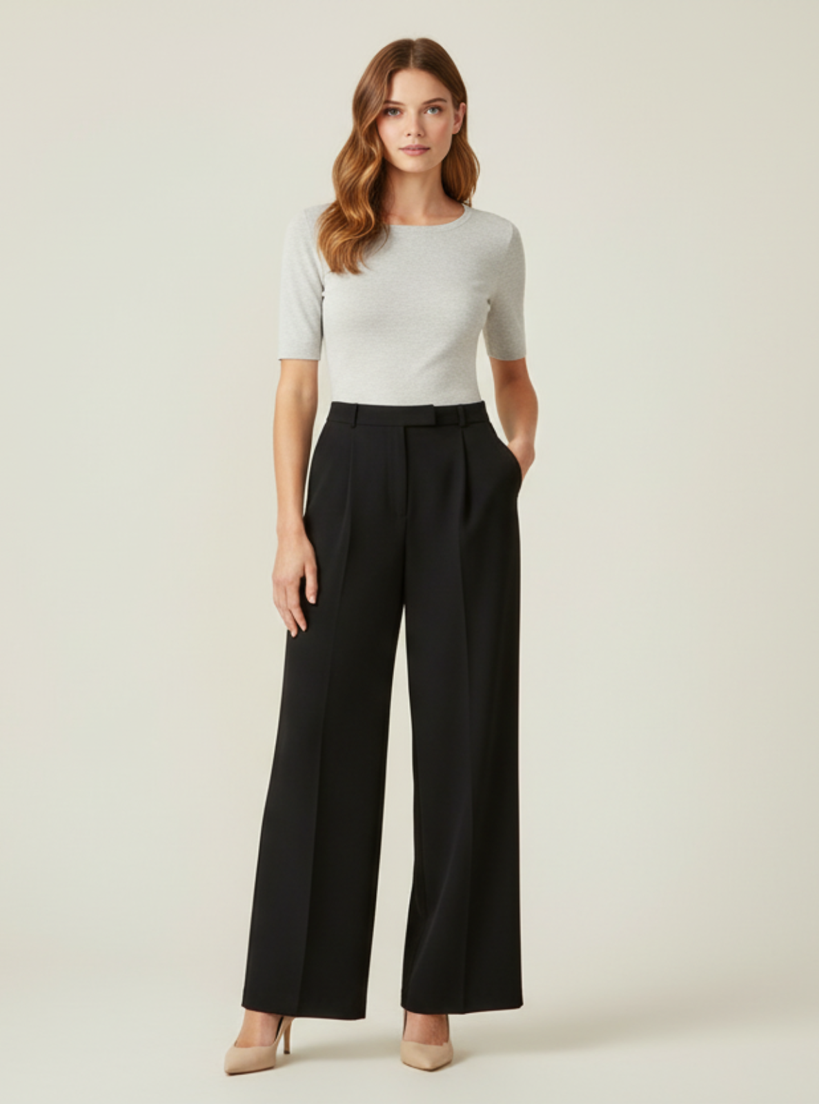 Woman wearing a white top and black pants on a beige background