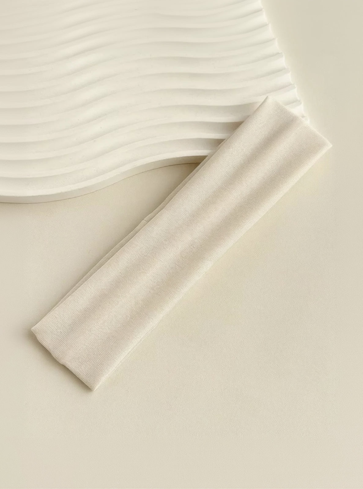 Close-up of beige fabric with a subtle texture on a light background