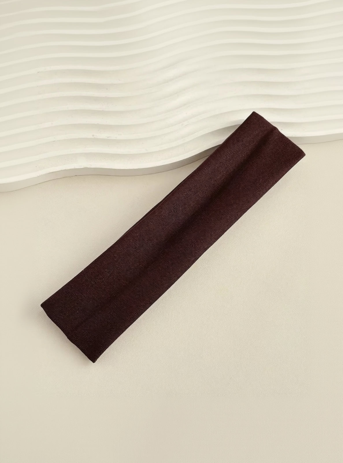 Brown headband on a beige surface