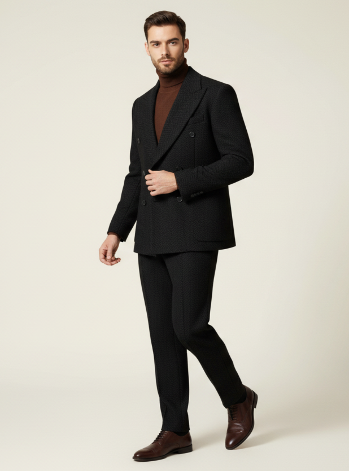 Man wearing a black suit with a brown shirt on a beige background