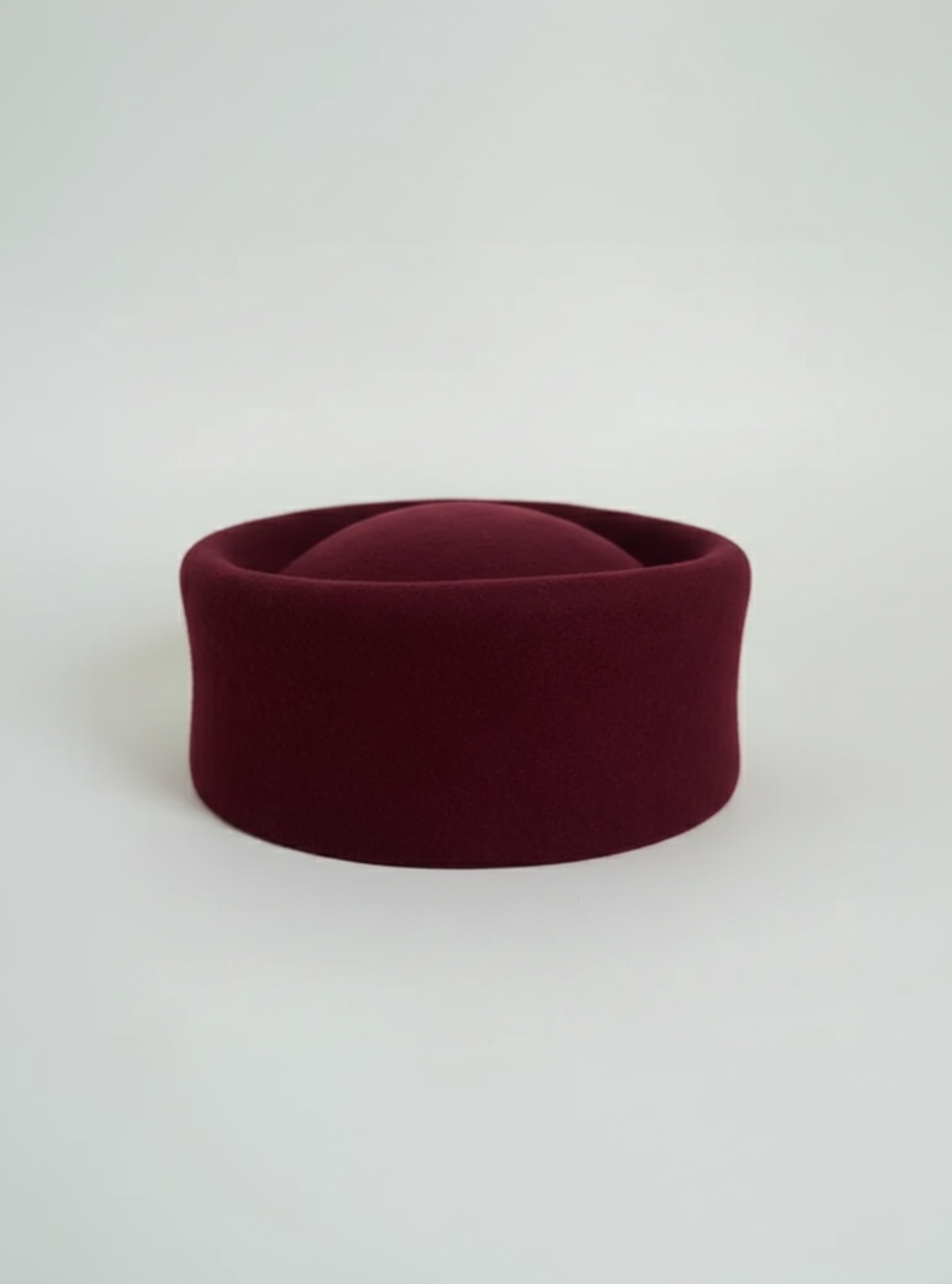 Maroon felt hat on a white background