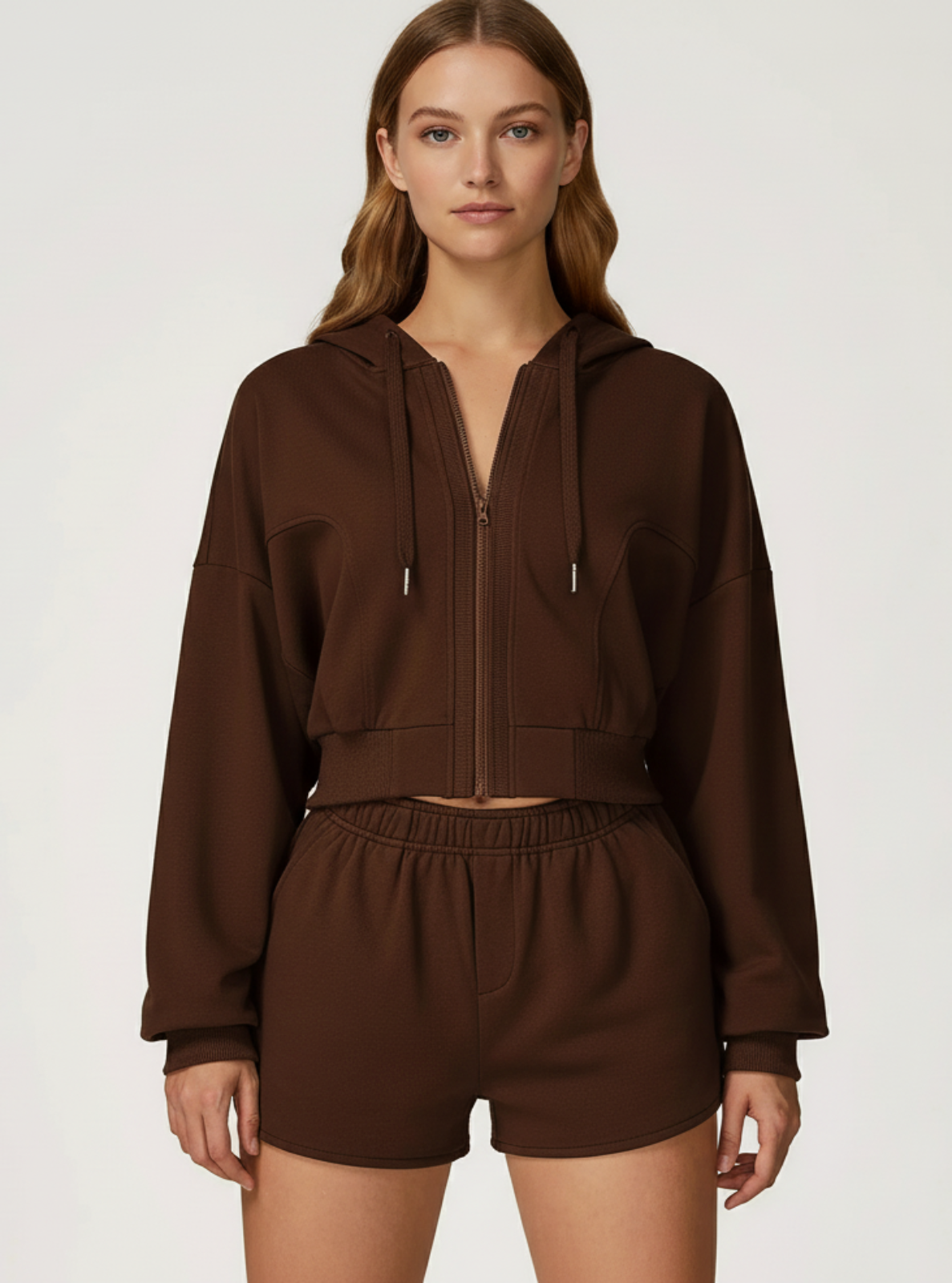 Woman wearing a brown hoodie and shorts set on a white background