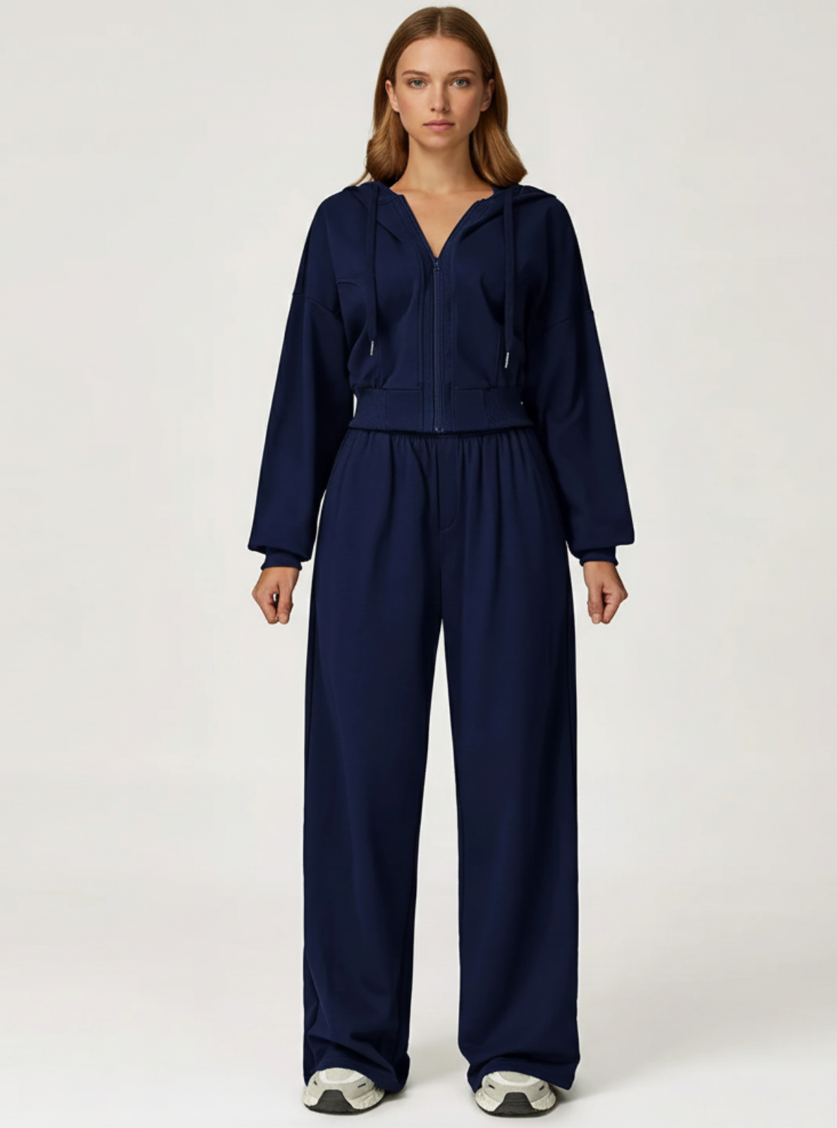 Woman wearing a navy blue tracksuit on a white background