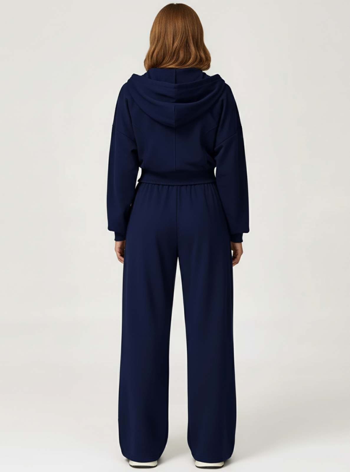 Person wearing a navy blue jumpsuit on a white background