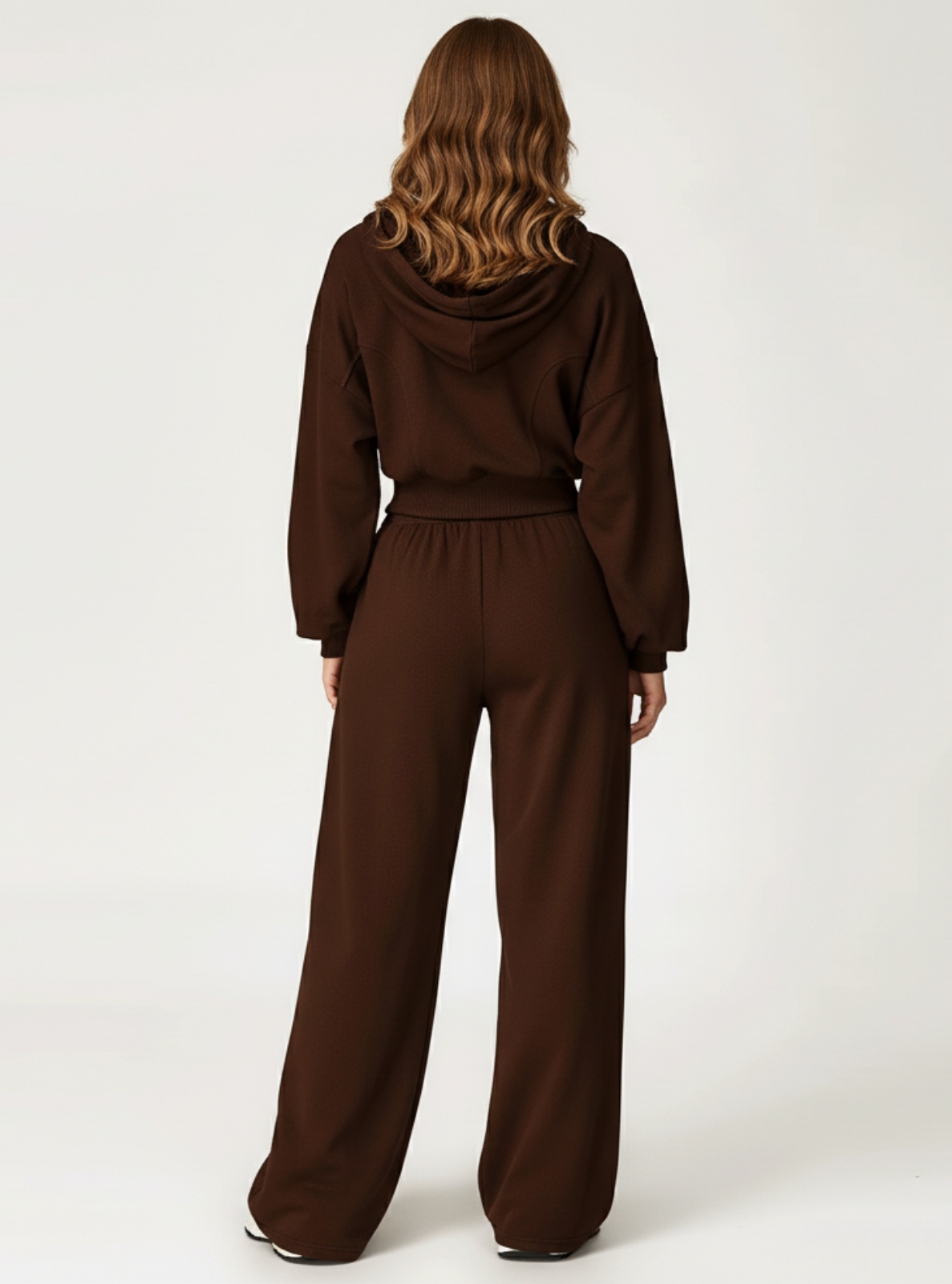 Person wearing a brown tracksuit on a white background