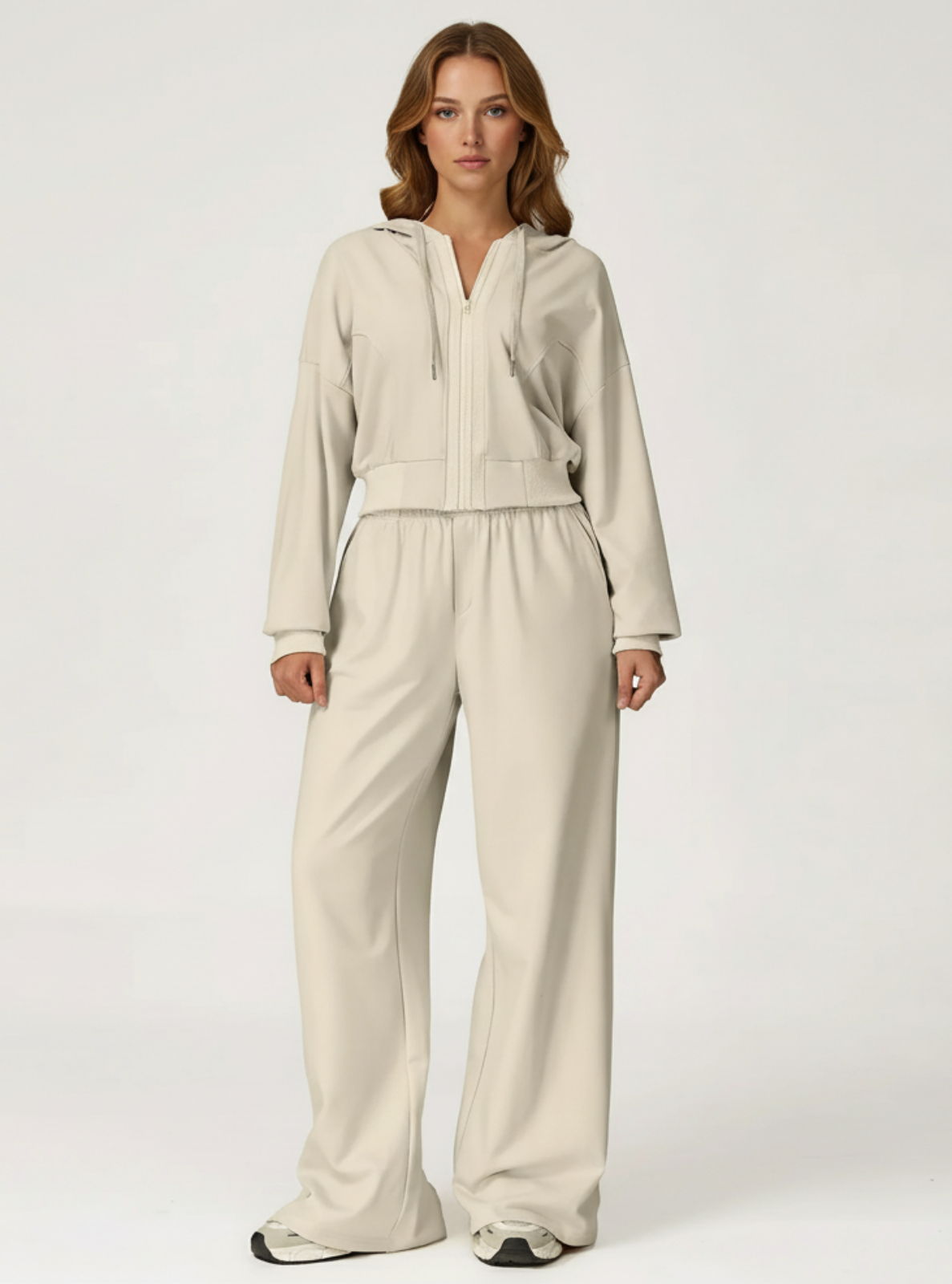 Woman wearing a beige tracksuit on a white background
