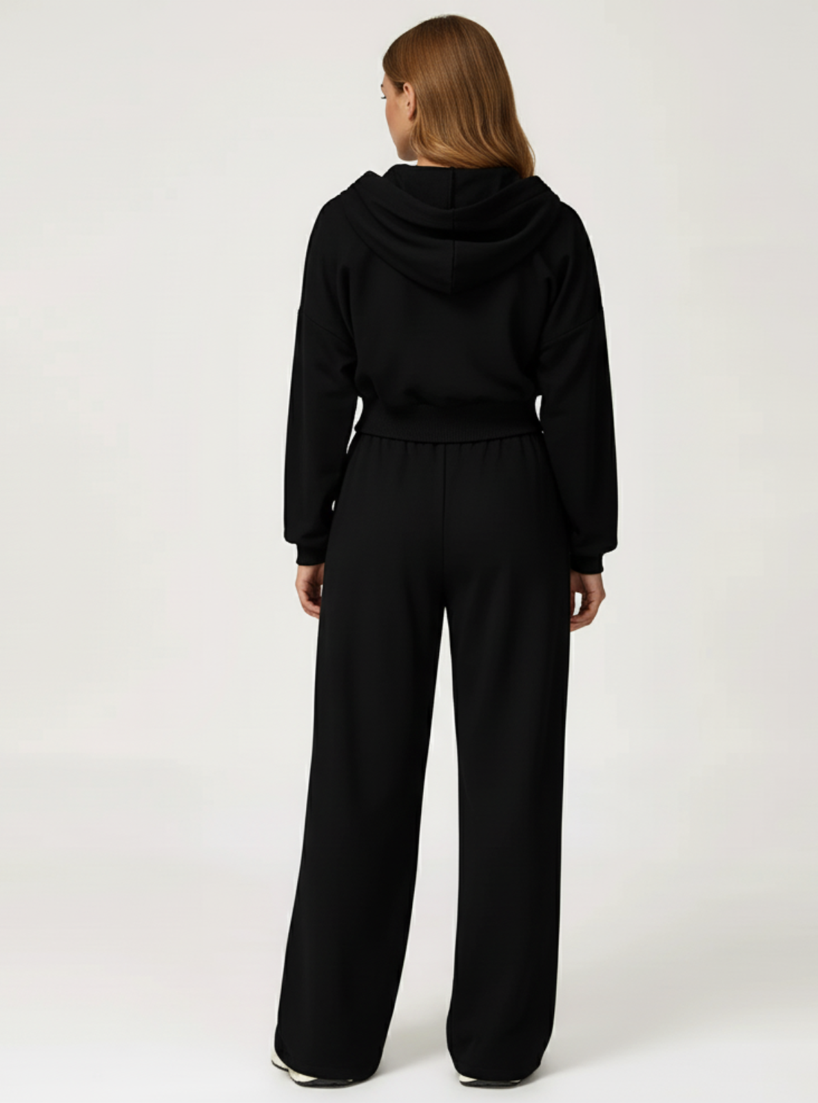 Person wearing a black tracksuit on a white background