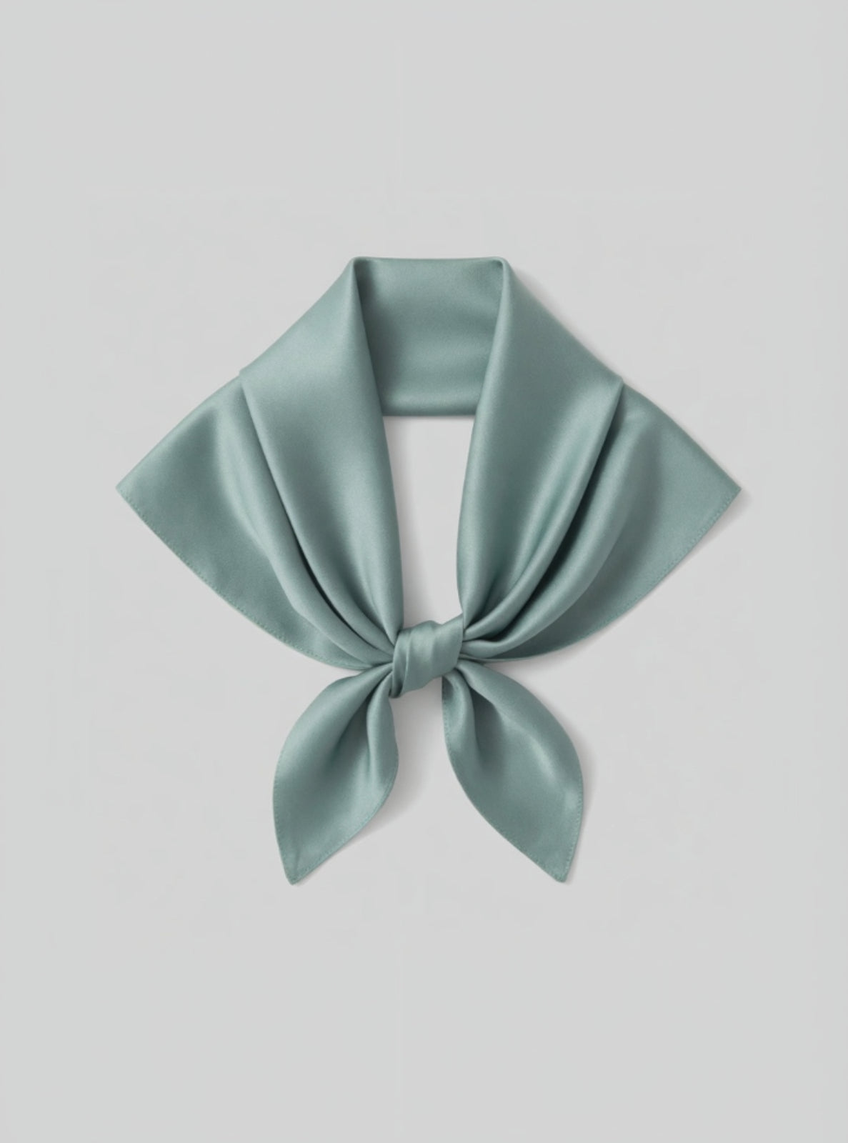 Light green satin scarf tied in a knot on a light gray background