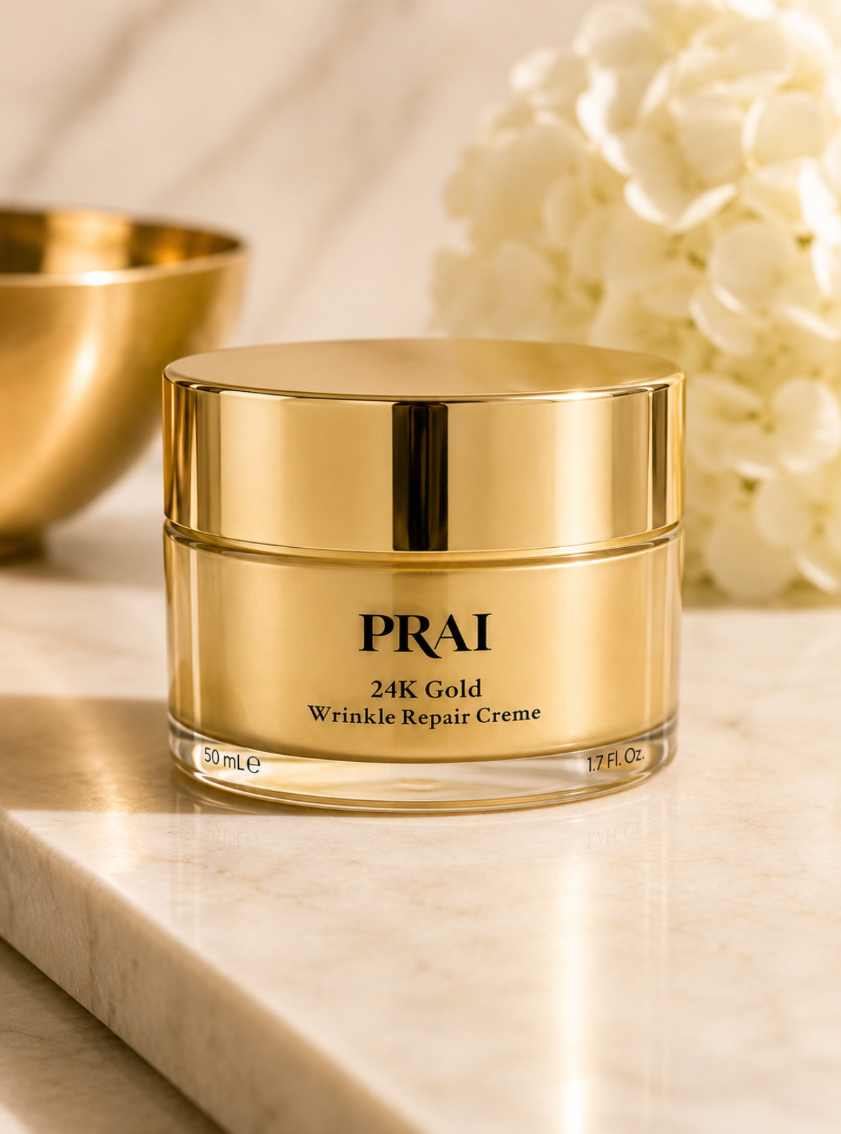 PRAI 24K Gold Wrinkle Repair Creme in a gold jar, set on a marble surface with a gold bowl and white flowers in the background.