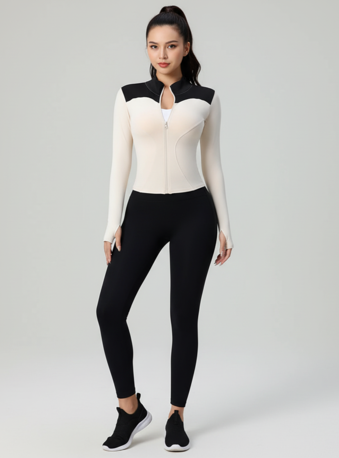 Person wearing a black and white outfit on a gray background