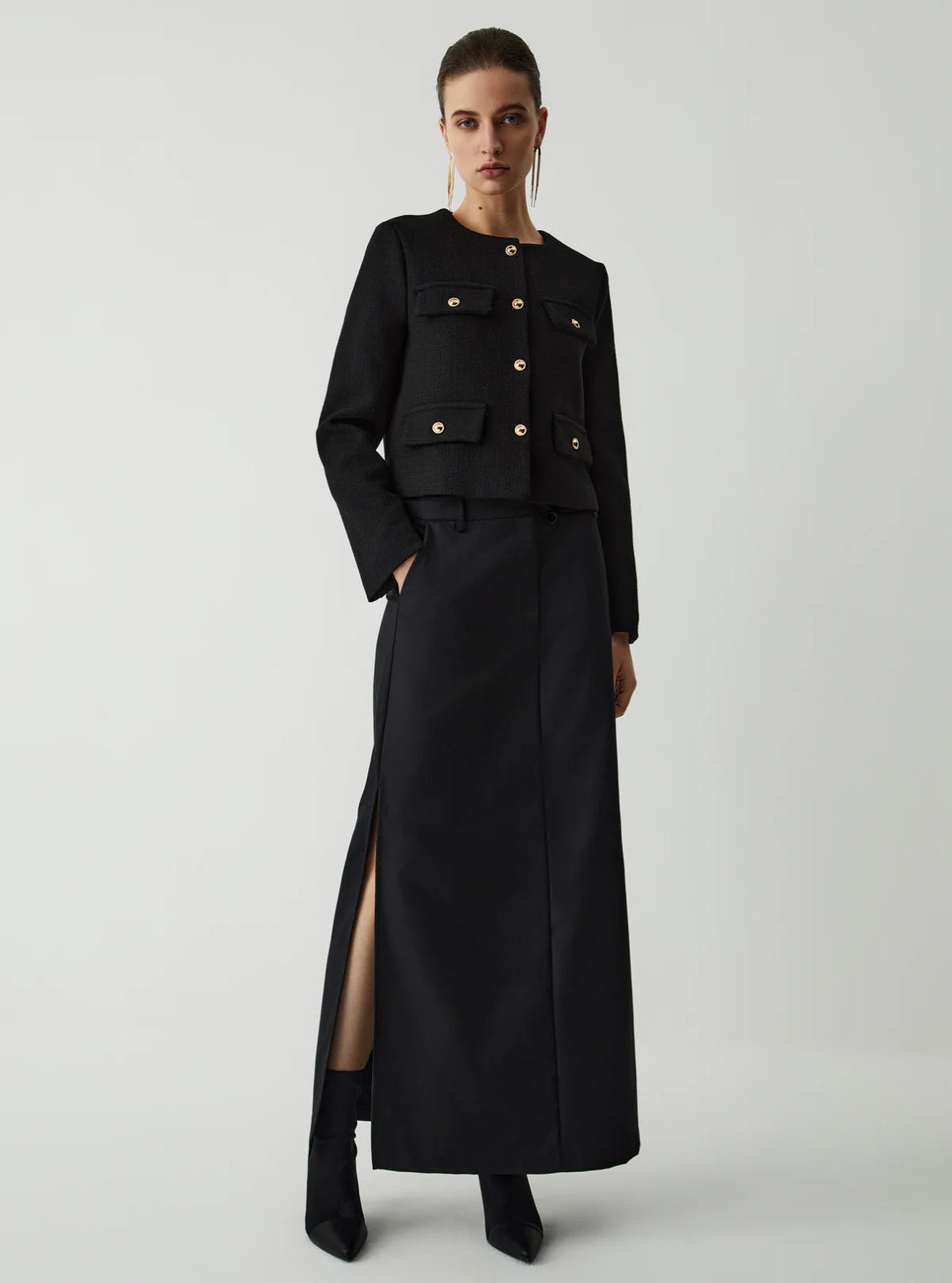Black textured Jacket on a model wearing a skirt and boots on a white background