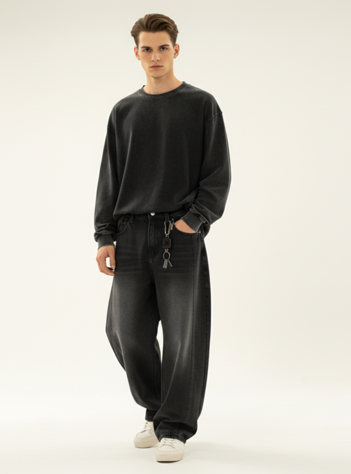 Man wearing a black sweater and jeans on a white background