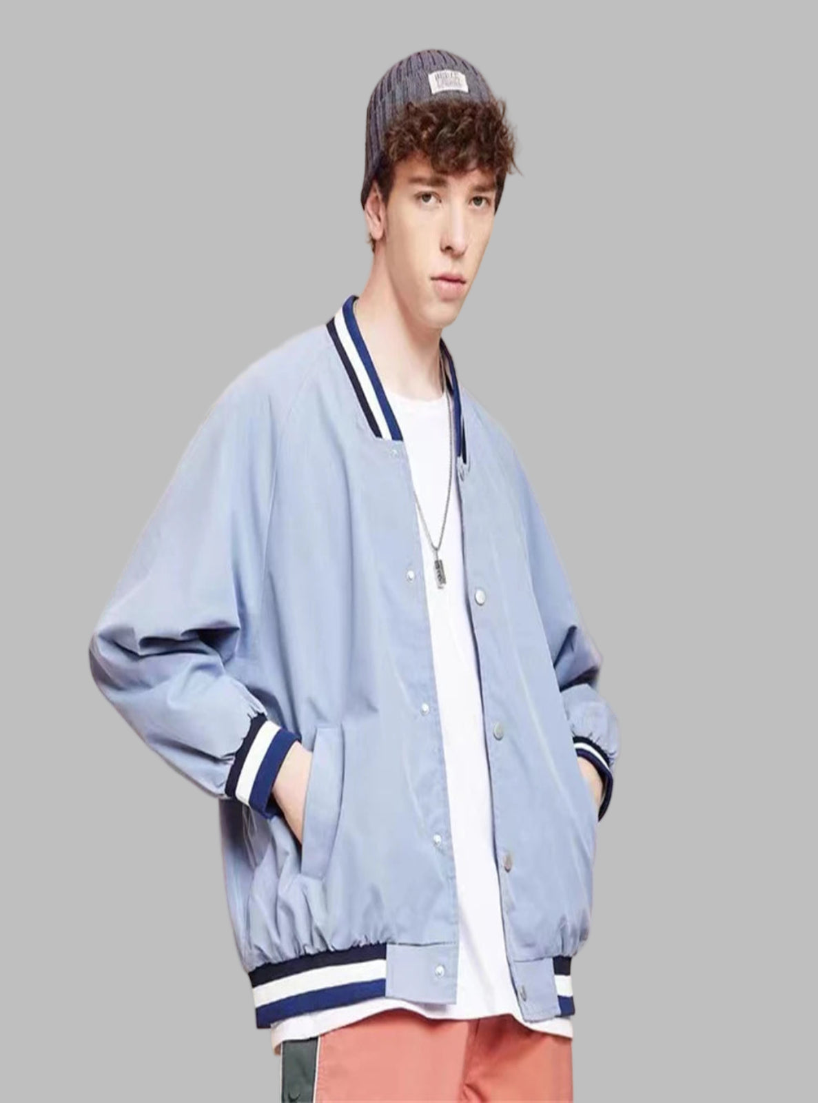 Person wearing a light blue varsity jacket with dark blue accents on a beige background