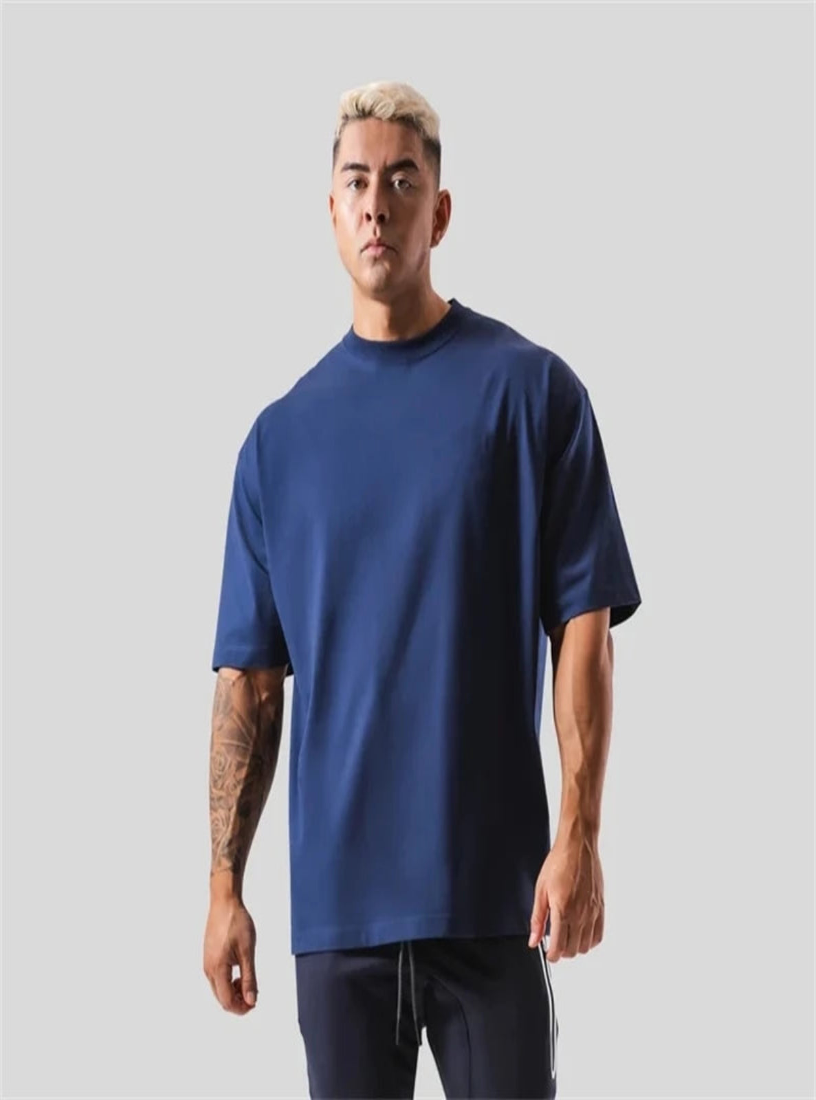 Man wearing a blue t-shirt against a gray background
