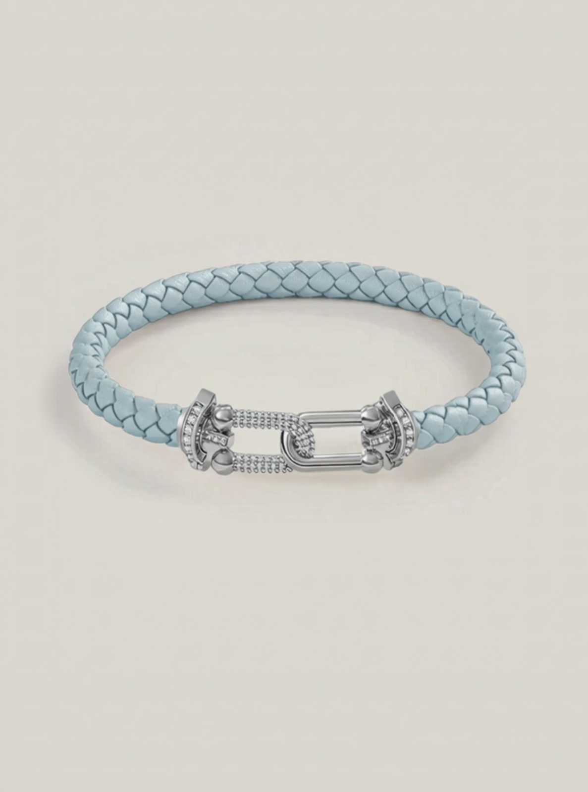Light blue braided bracelet with silver clasp on a light beige background