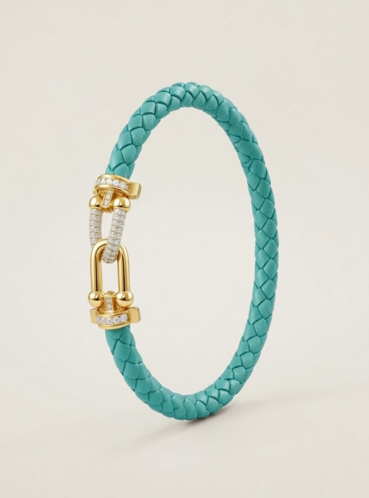 Turquoise braided bracelet with a gold clasp on a light gray background
